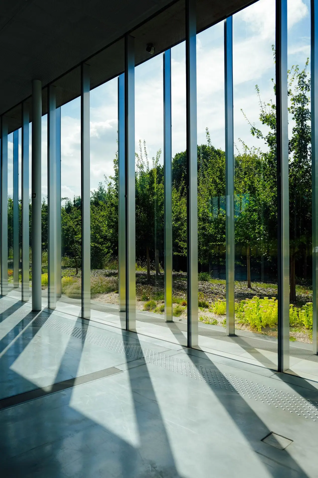 What Is Low-E Glass and How It Improves Building Performance Interior space with large Low-E glass windows allowing natural daylight while improving energy efficiency