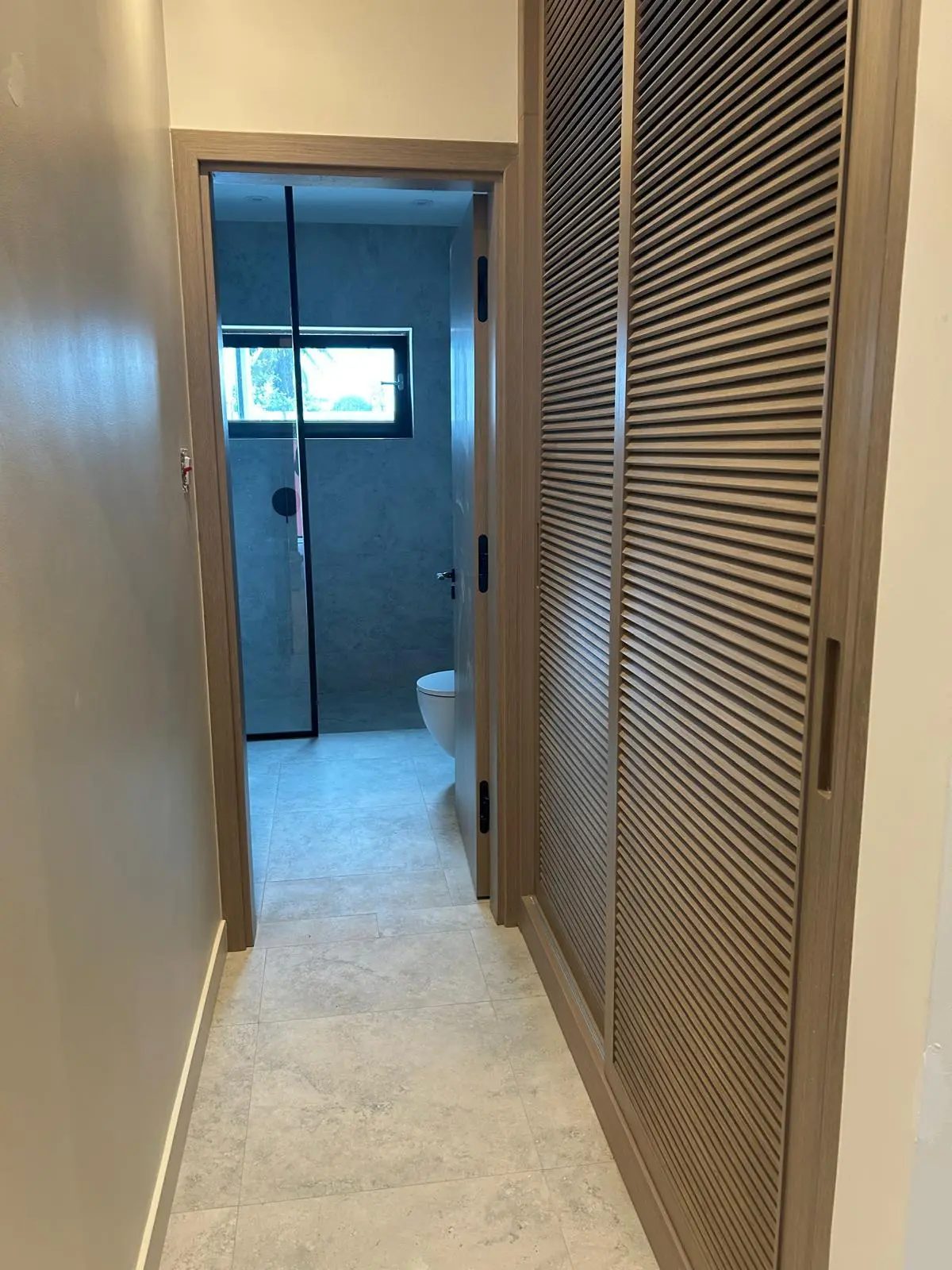 160 Atlantic corridor featuring custom louvered doors, wall finishes, and architectural detailing sourced by Guangzhou Sourcing