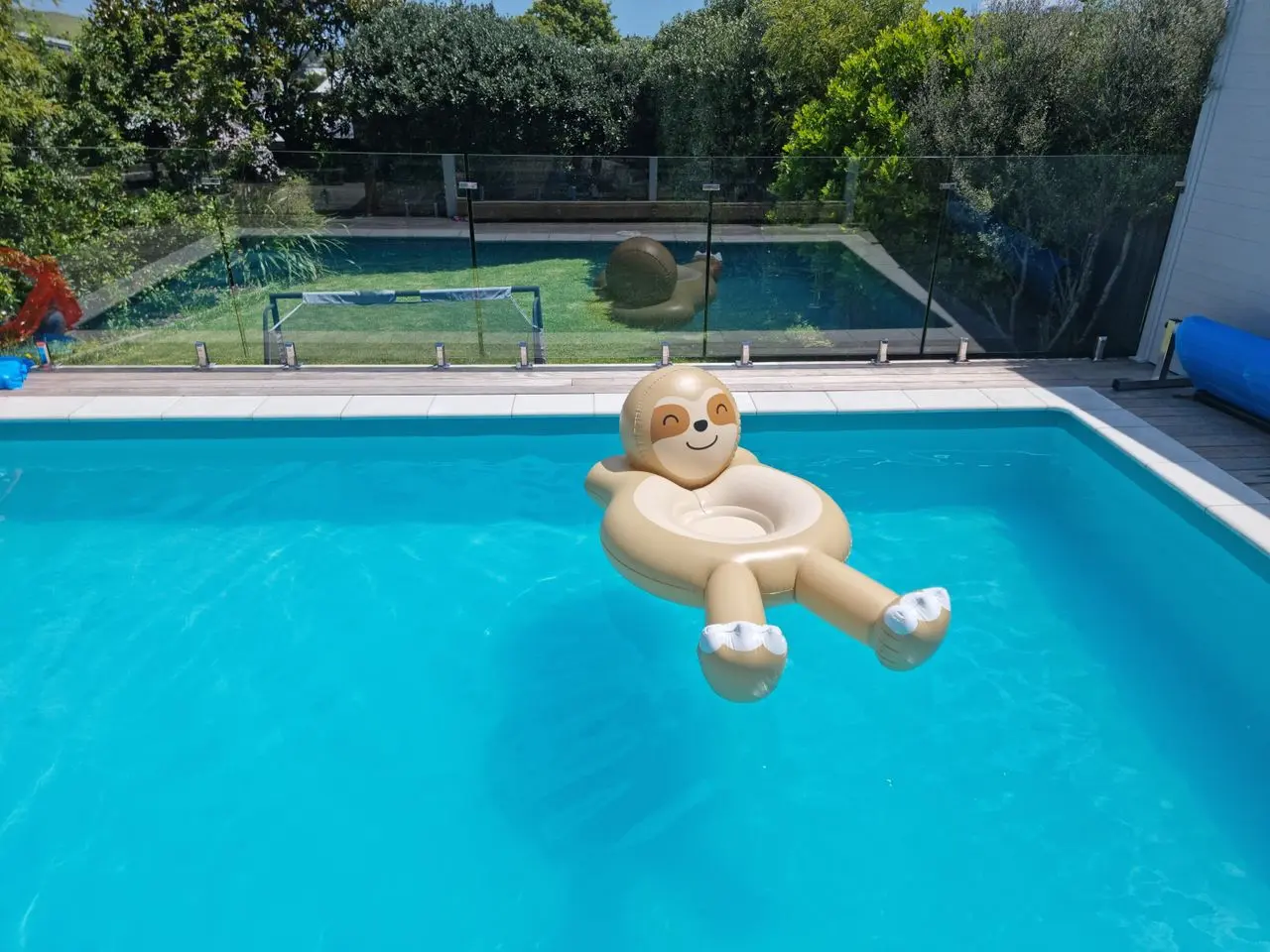 Frameless glass swimming pool fencing installed around a modern residential outdoor pool