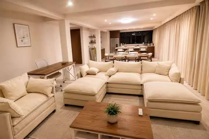 Crystal View spacious lounge featuring premium sectional seating, curtains, and contemporary interior