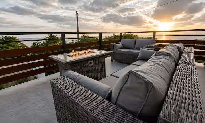 Crystal View outdoor lounge featuring premium woven furniture, fire pit table, and scenic ocean sunset views in Dominica