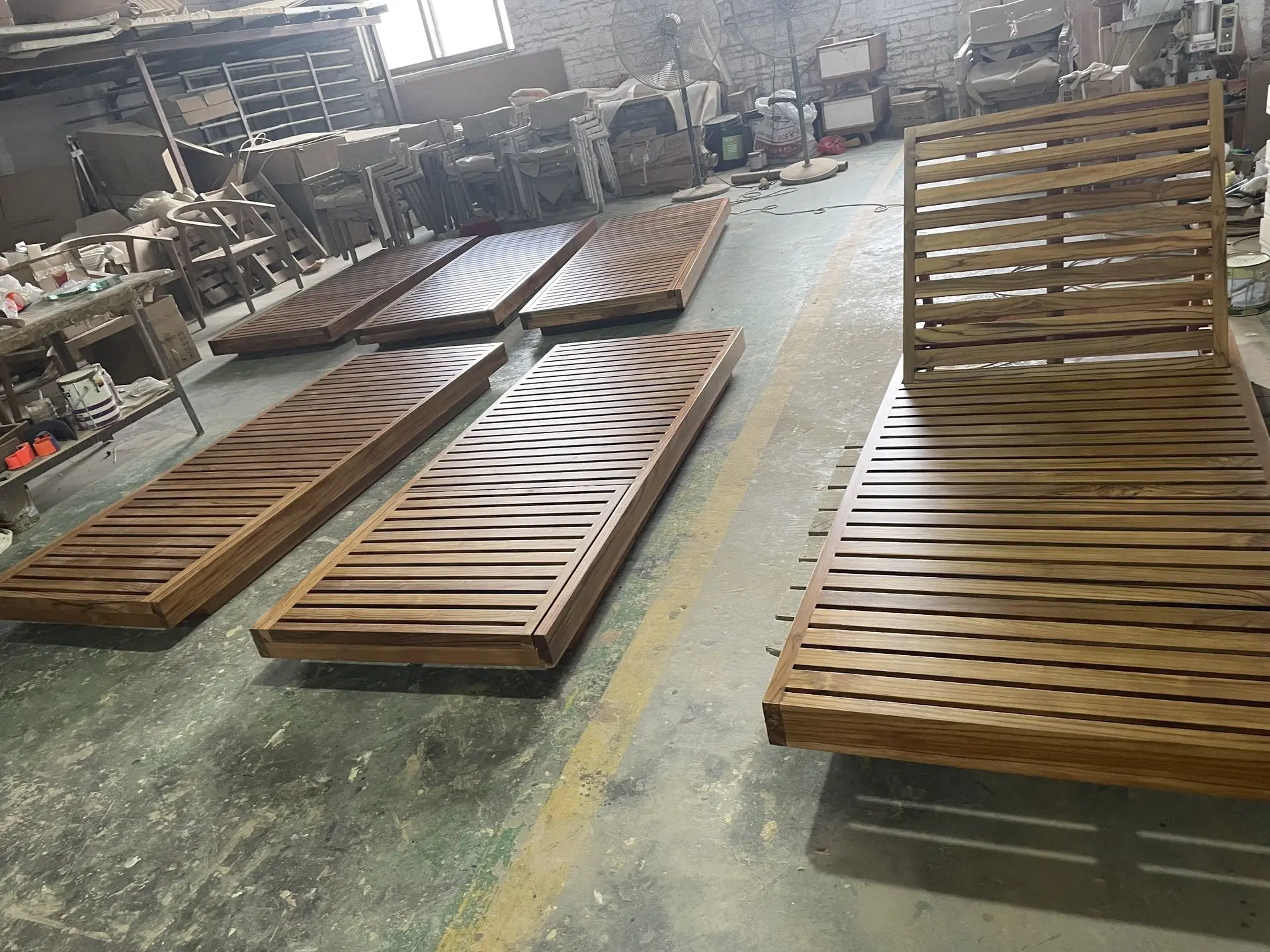 Teak outdoor furniture sun loungers in production at a furniture factory in China