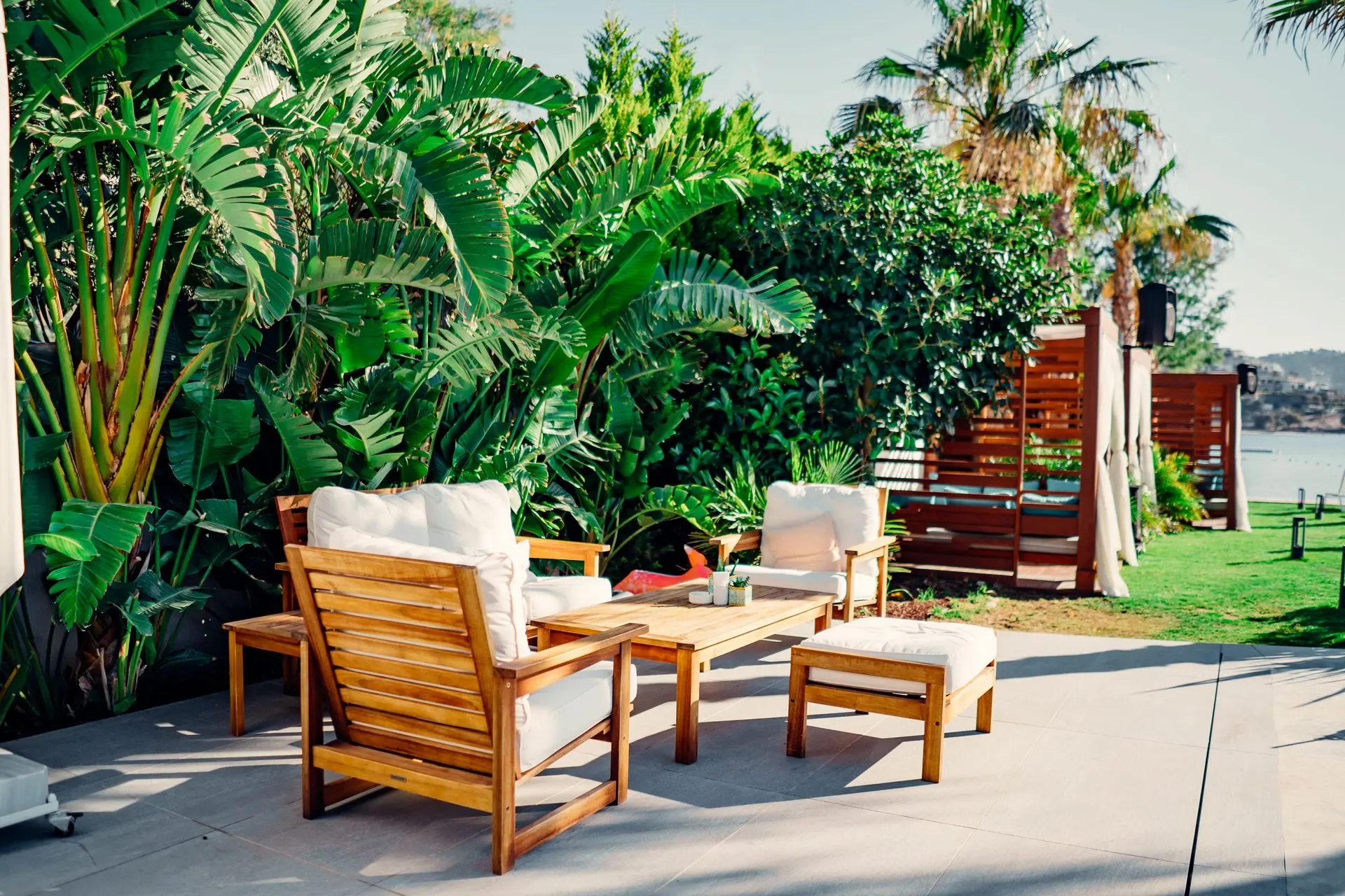 Teak Outdoor Furniture for Luxury Patios, Resorts, and Gardens Teak outdoor furniture set with sofa, chairs, coffee table, and ottoman in a luxury garden patio