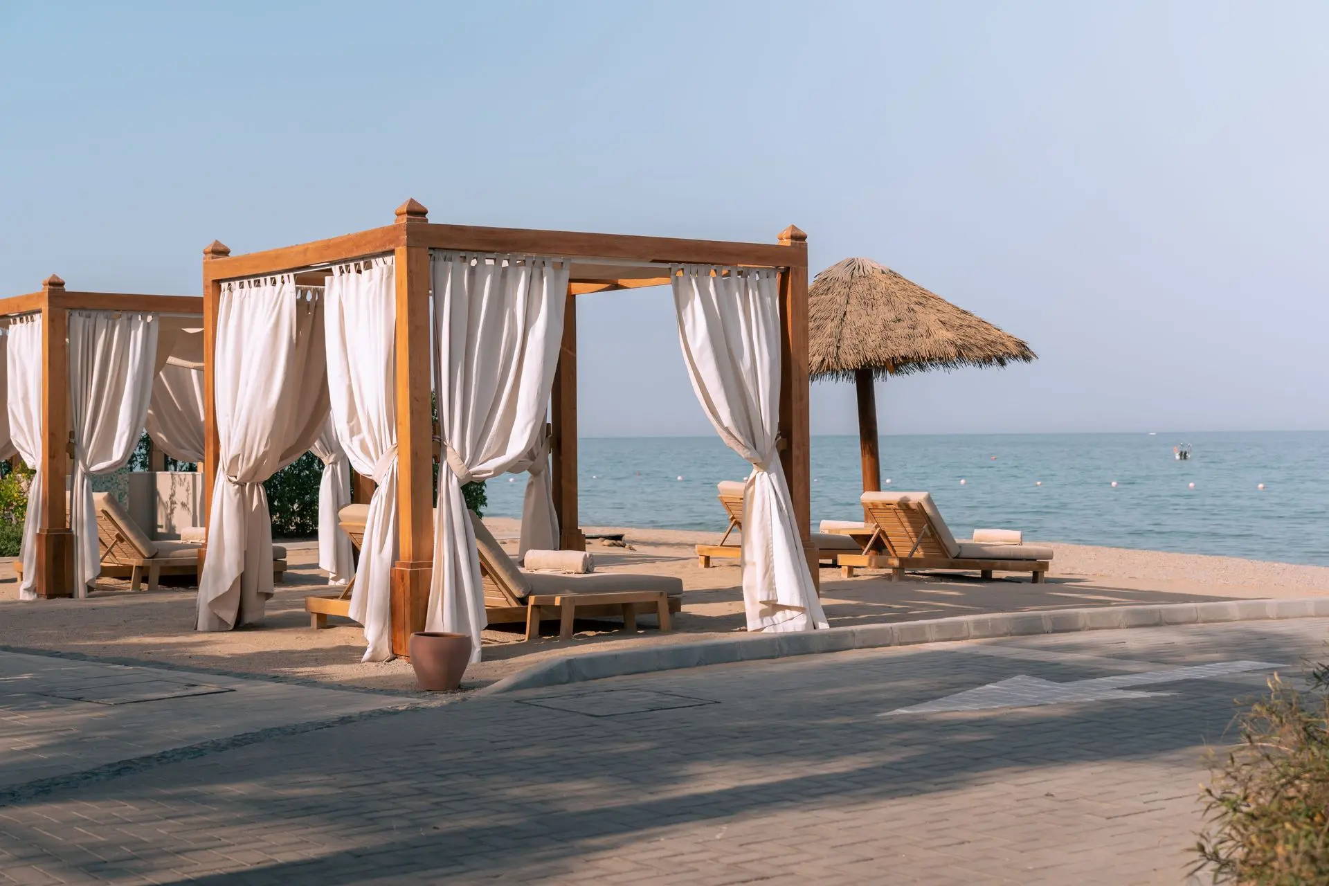 Teak Outdoor Furniture for Luxury Hotels, Resorts, and Beachfront Spaces Teak outdoor furniture cabanas and sun loungers at a luxury beachfront resort