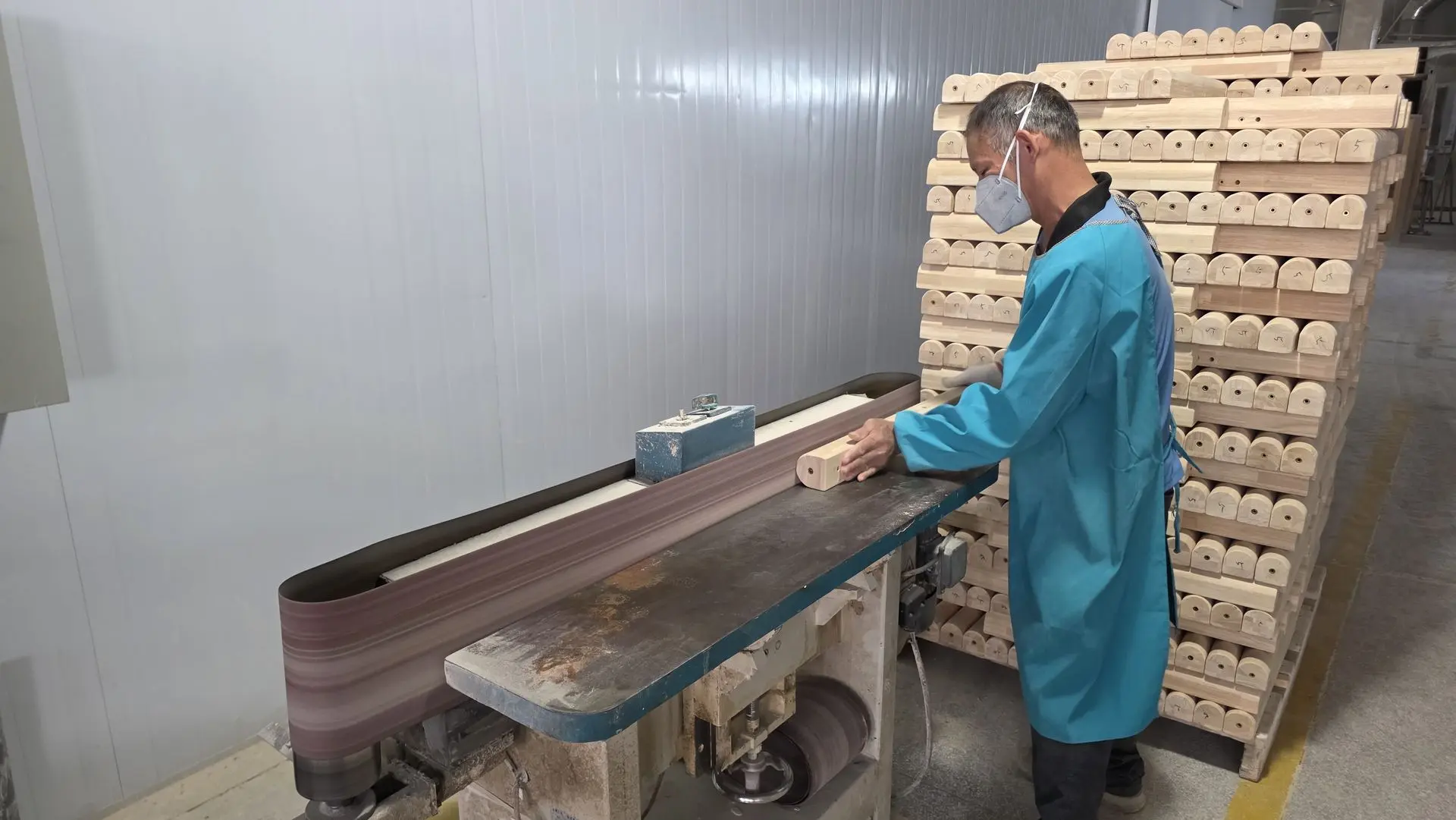 Quality Inspection and Surface Finishing for Decorative Wood Carving Products Worker inspecting and sanding decorative wood carving components to ensure a smooth surface finish before final quality inspection
