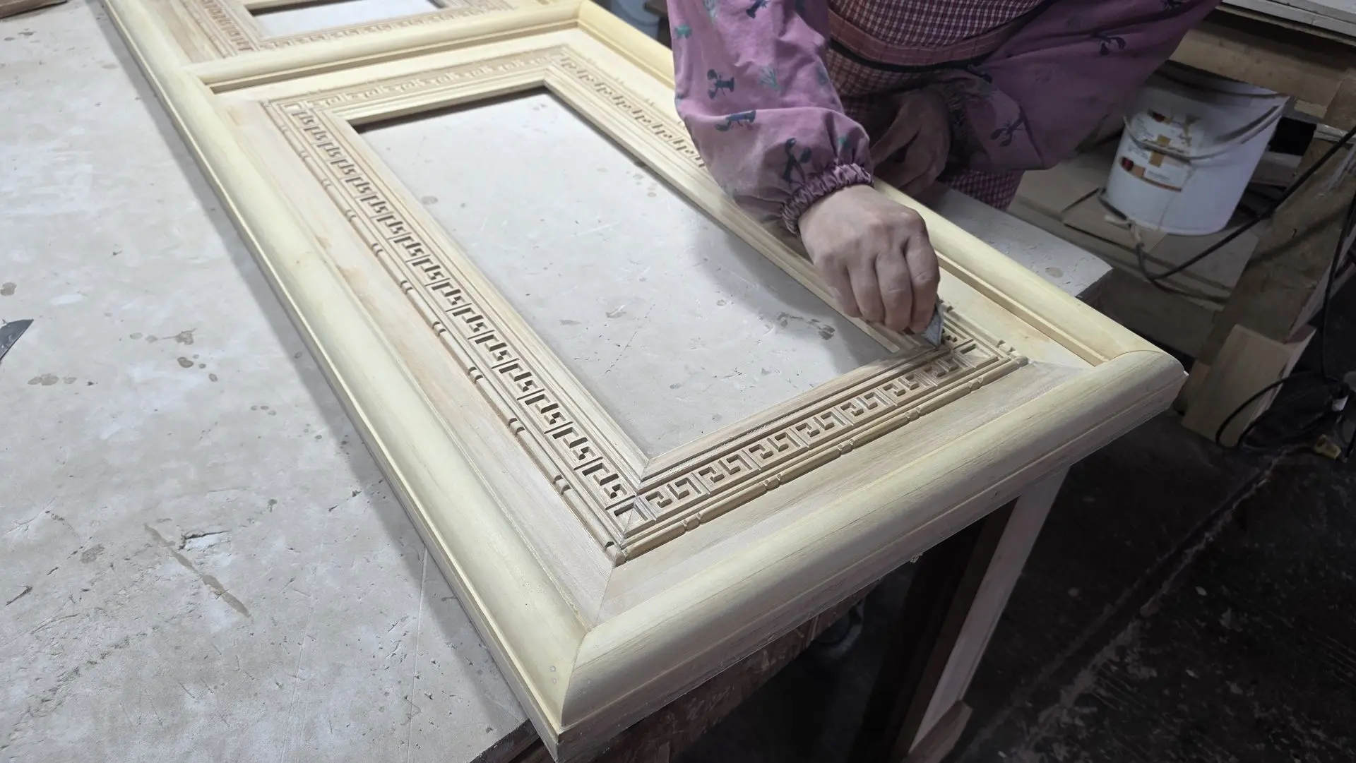 Quality Surface Finishing for Decorative Wood Carving Products Skilled craftsman hand-finishing a decorative wood carving door frame to ensure a smooth surface and precise carved details
