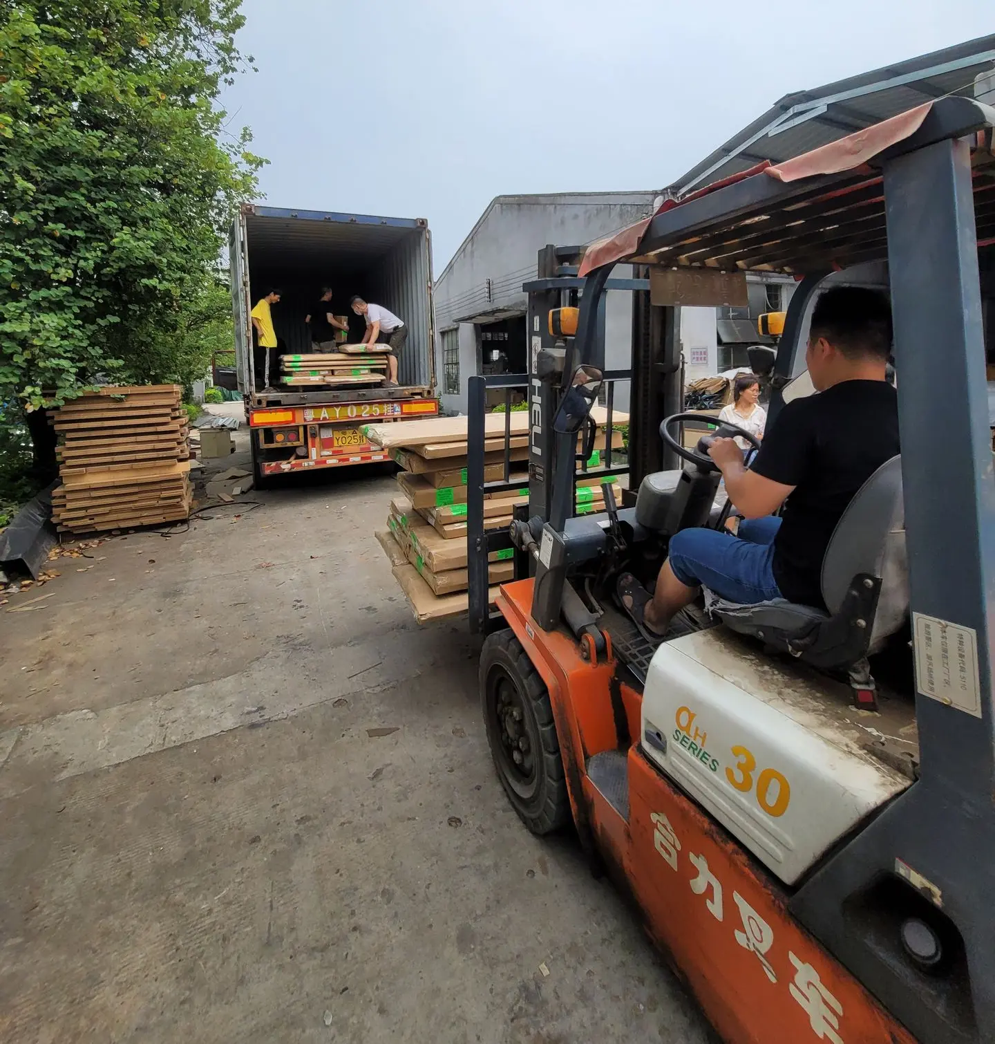 Warehouse team loading building materials into a shipping container for overseas shipment