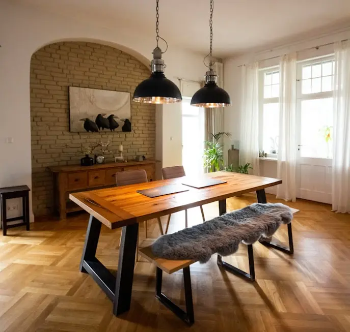 RH-inspired solid wood dining table with industrial pendant lights in a luxury dining room