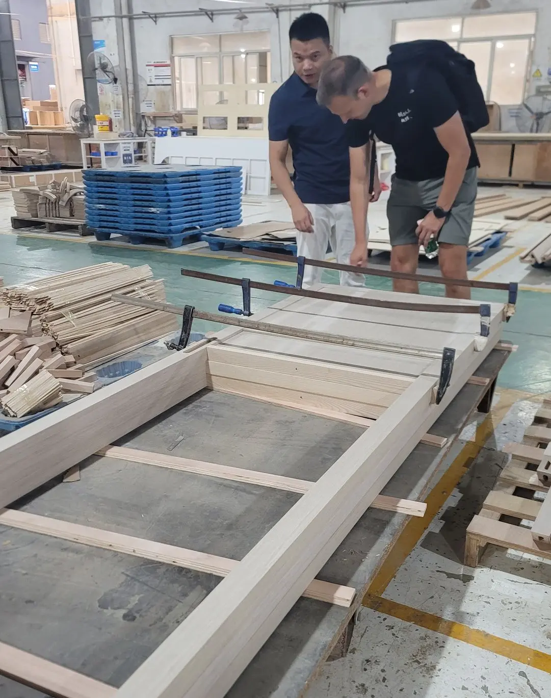 Furniture Factory Inspection During a China Sourcing Trip Buyer inspecting custom wood furniture with a factory representative during a factory visit in China