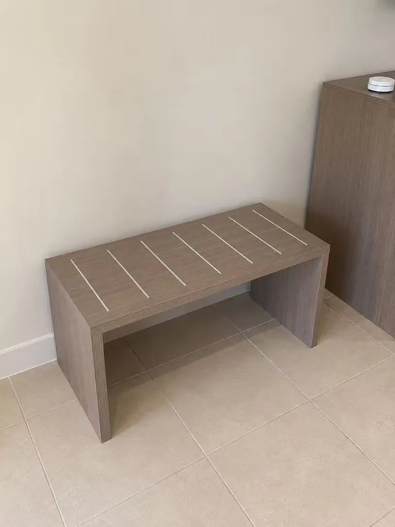 Wooden hotel bedroom bench positioned at the foot of the bed