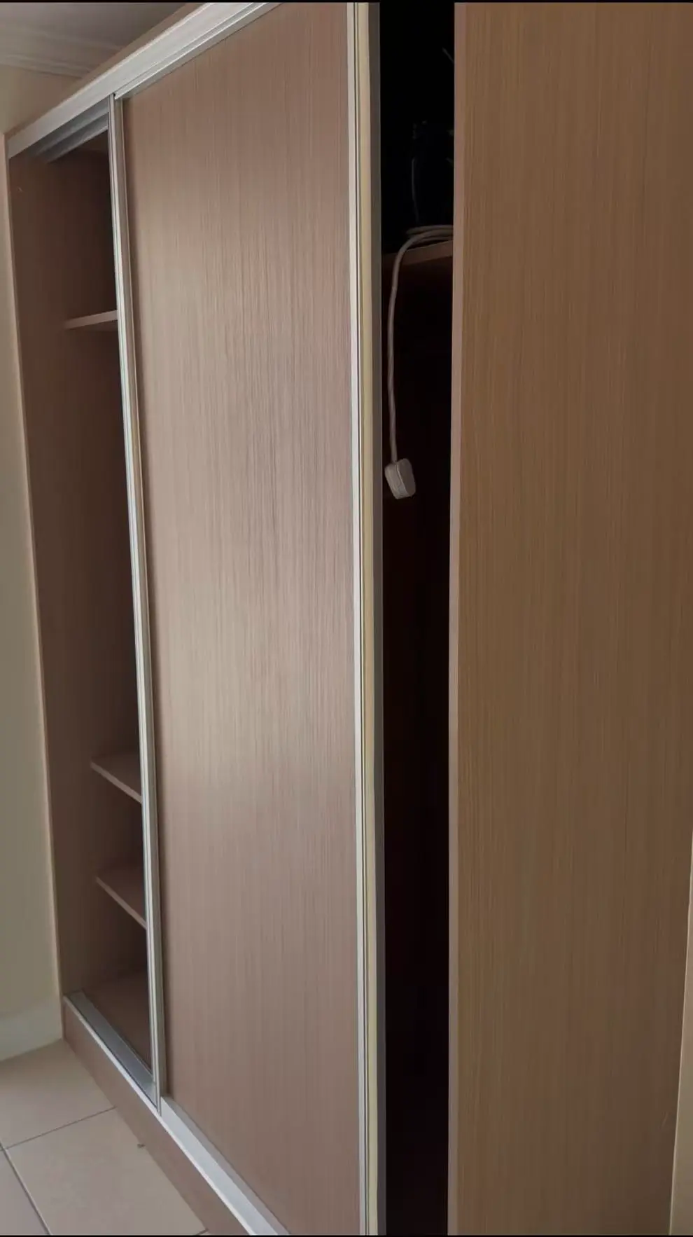 Built-in wooden wardrobe for hotel guest room with sliding doors and storage