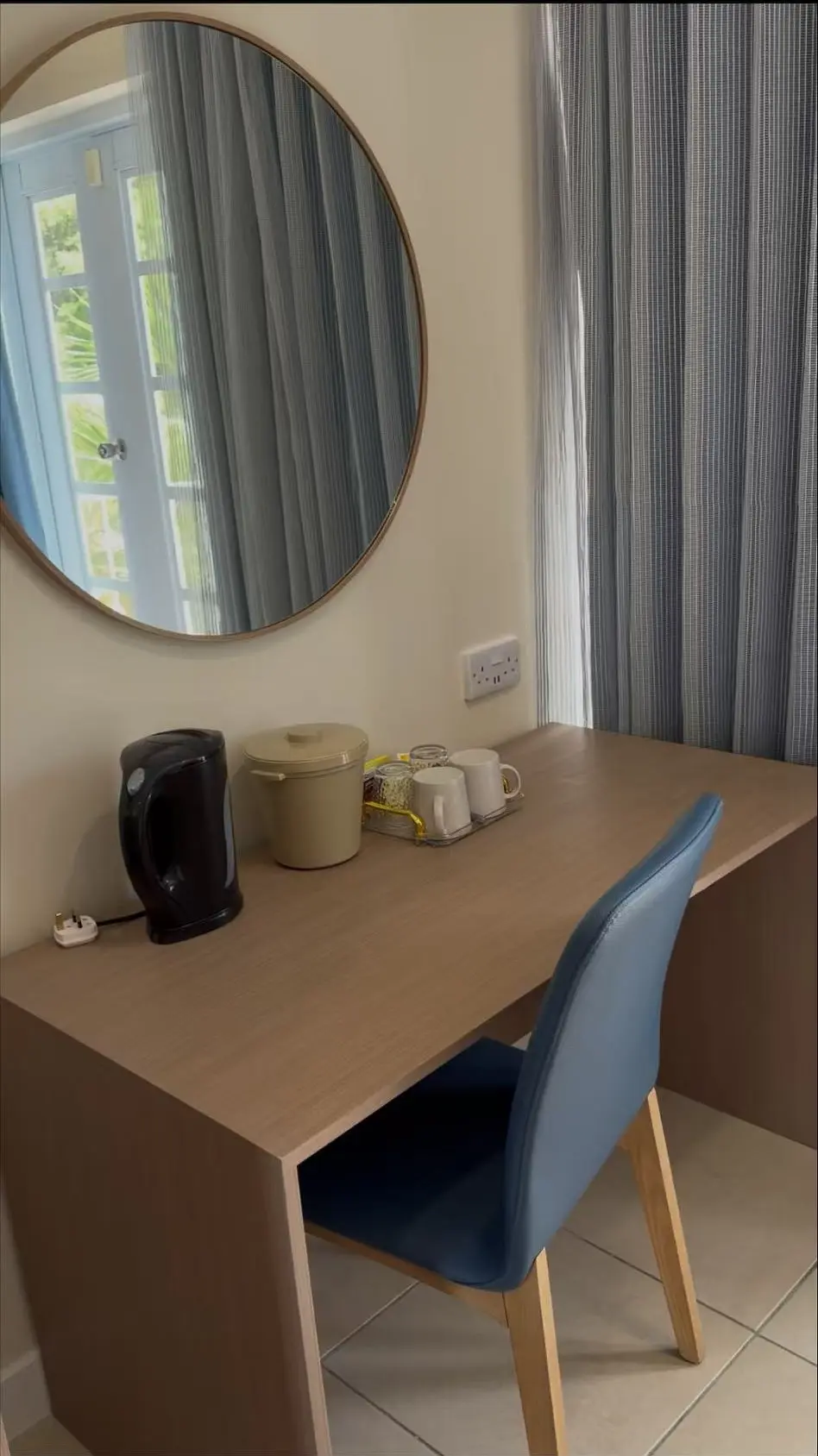 Hotel guest room vanity desk with round mirror, chair and modern millwork