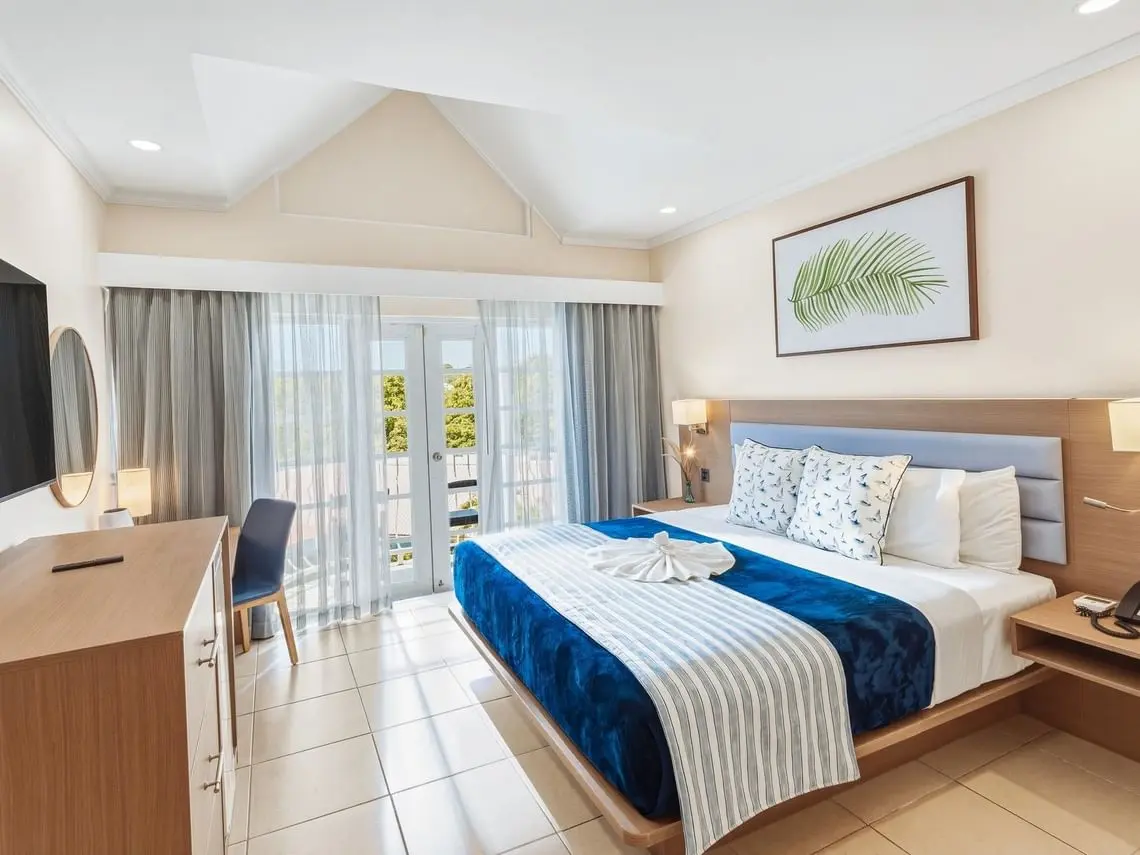 Bay Gardens Marina Haven guest room with king bed, desk, blue bedding and custom furniture