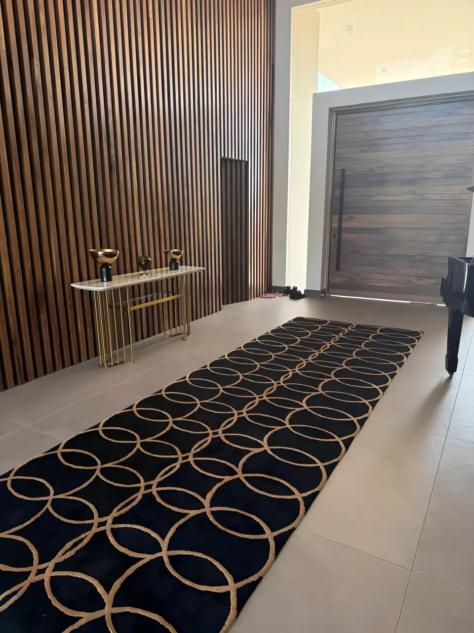 Luxury villa entrance hall in Mauritius with decorative console table, patterned carpet and wood feature wall