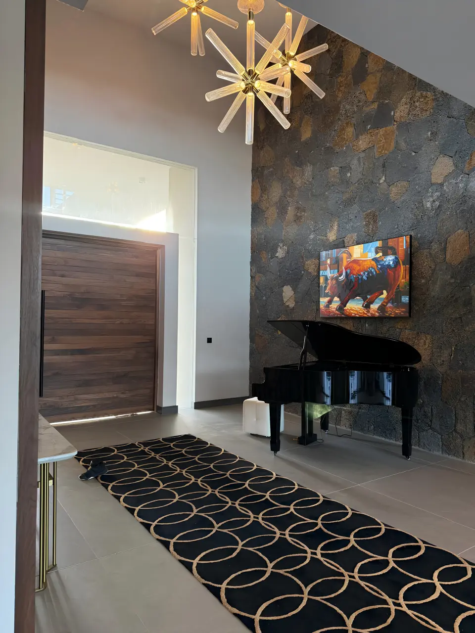 Mauritius residential villa entrance with grand piano, stone feature wall, artwork and decorative carpet