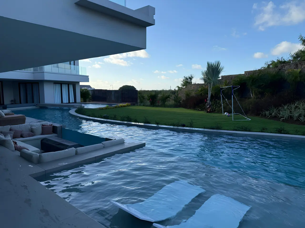 Luxury residential villa swimming pool in Mauritius with sun loungers and outdoor seating area