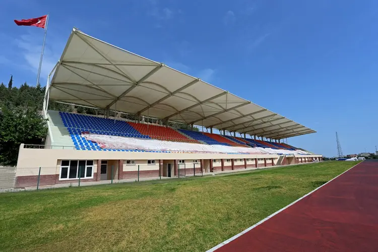 Large tensile canopy covering stadium seating and sports track