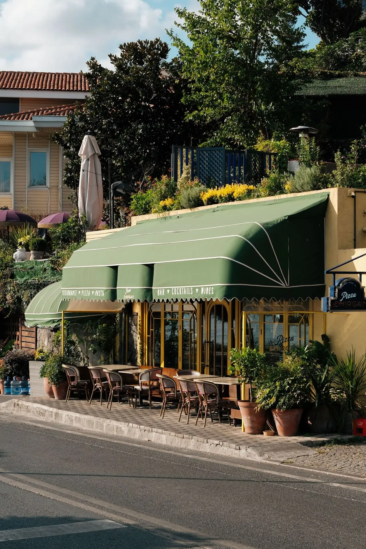 Green awning shading an outdoor restaurant seating area