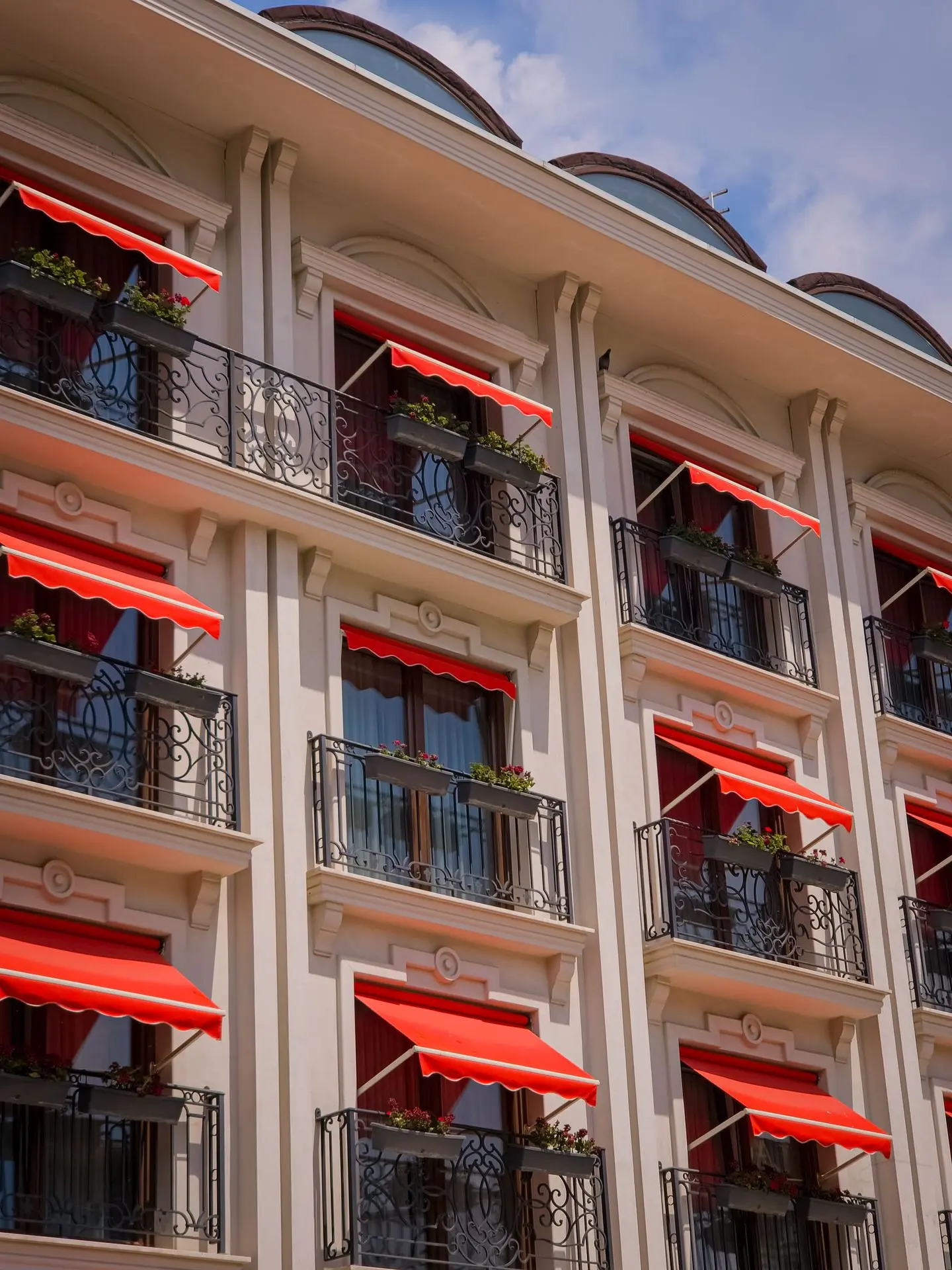 Red awnings providing shade over windows and balconies