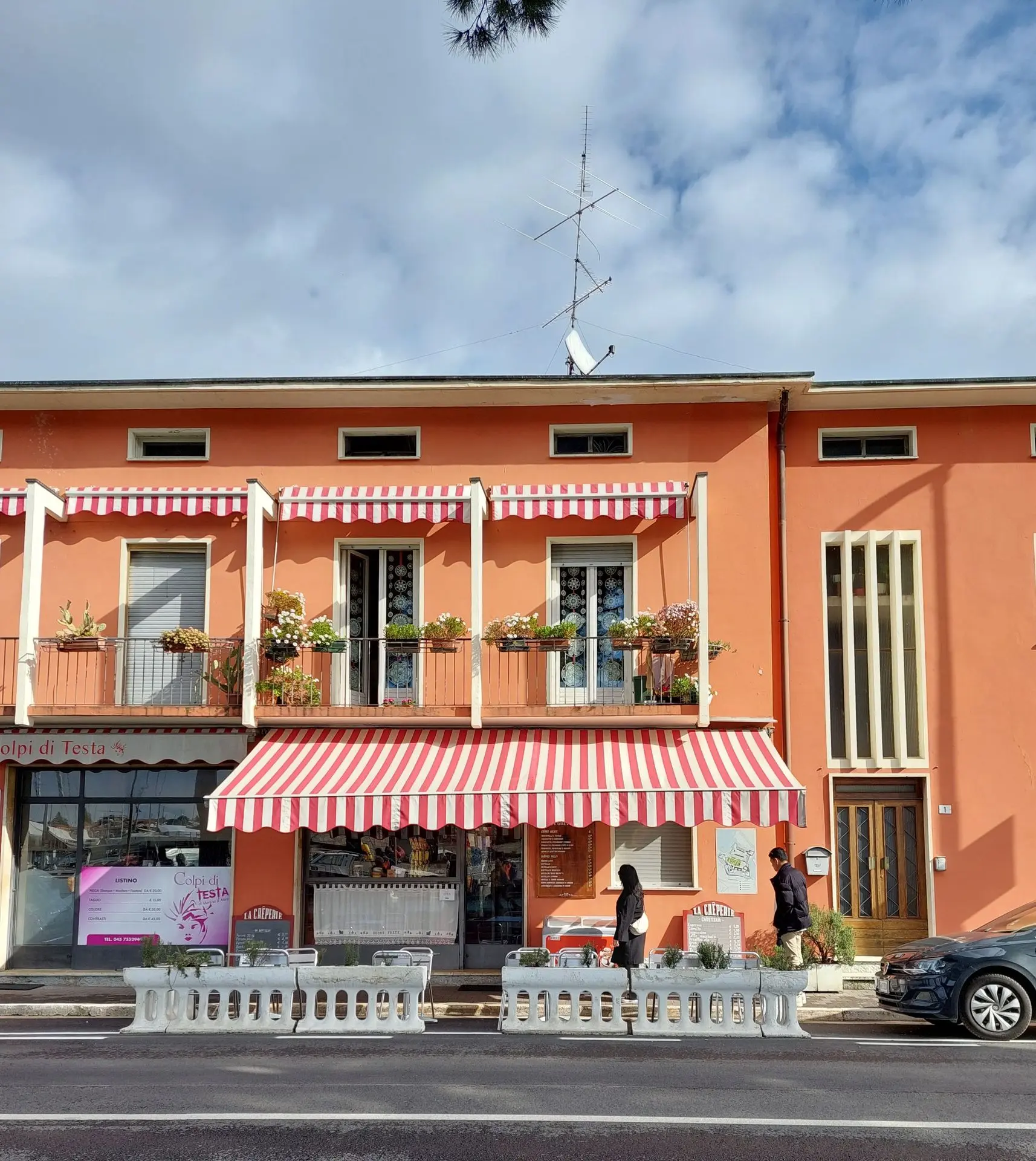 Red and white striped awnings shading a café storefront and balconies