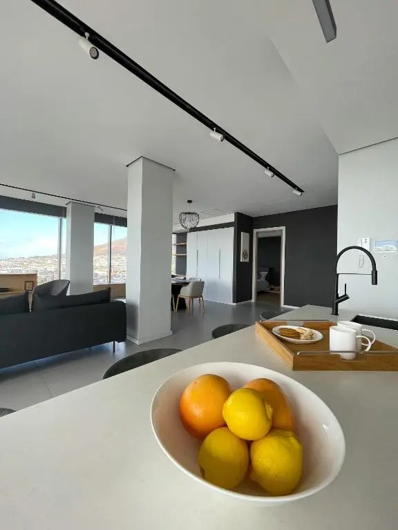 Kitchen counter with a bowl of assorted fruit, including apples, bananas, and oranges.